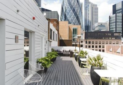 Roof terrace with white wire chairs and views of the Gherkin building.