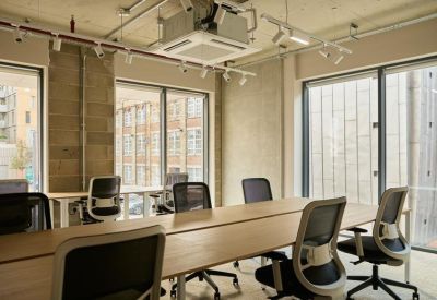 Internal office room with grey ergonomic chairs and floor-to-ceiling windows.