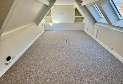 Long attic workspace with multiple skylights and recessed lighting.