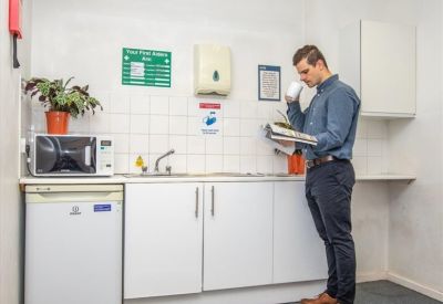 Communal kitchen area with microwave, sink, and mini fridge.