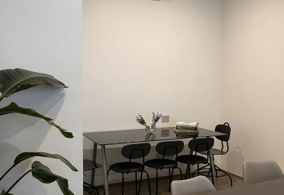 Close-up of a workstation with black chairs and white walls.