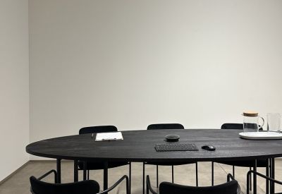 Dark wood oval conference table with stylish black chairs.