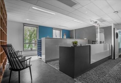 Professional reception area with a black and white desk and modern wood shelving.