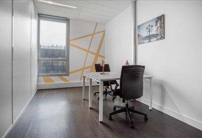 Private office suite with a geometric wall mural and two desks.