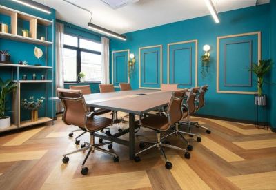 Meeting room with teal walls, wood paneling, and a large table.