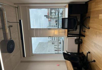 Bright office workspace with natural light, hardwood floors, and black ergonomic chairs.