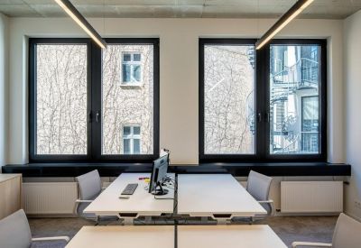Double workstation setup with large windows overlooking a courtyard.