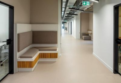Wide office corridor featuring a built-in banquette seating area with wood accents.