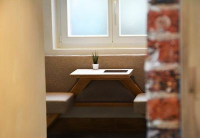 Communal dining nook with a wooden picnic-style table and a small potted plant.