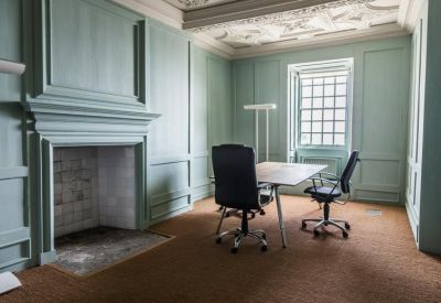 Light blue office with decorative wall molding and an ornate plaster ceiling.