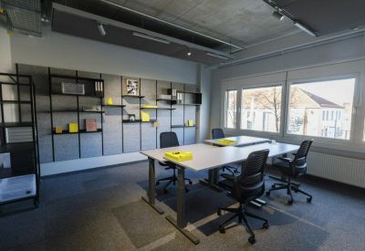 Spacious office with white desks and adjustable ergonomic chairs.
