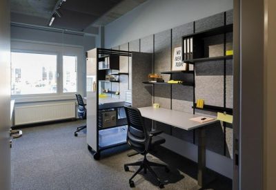 Private office workstation with wall-mounted shelving and a mobile storage unit.