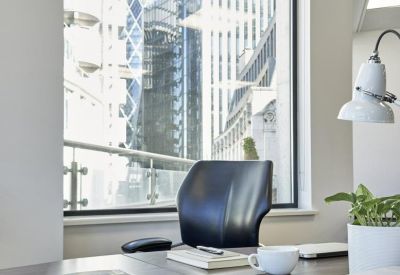 Private office desk with a view of iconic London skyscrapers through a large window.