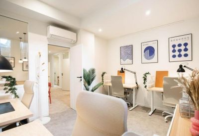Bright workspace featuring several ergonomic desks and creative wall art.