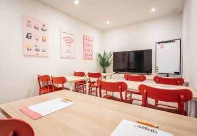 Close-up of a meeting table arranged with notebooks and red seating.