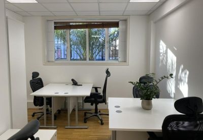 Bright private office suite with white desks, ergonomic chairs and wood flooring.
