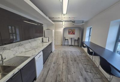 Communal break area featuring a breakfast bar, high stools, and a coffee machine.