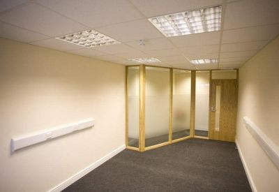 Private internal office suite with frosted glass partition and wood trim.