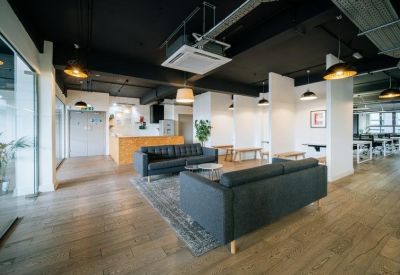 Reception area with black leather sofas and exposed black ceiling.