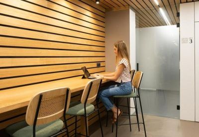 Individual working at a high counter with wooden panels.