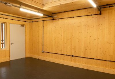 Minimalist studio space featuring natural light wood walls and dark flooring.