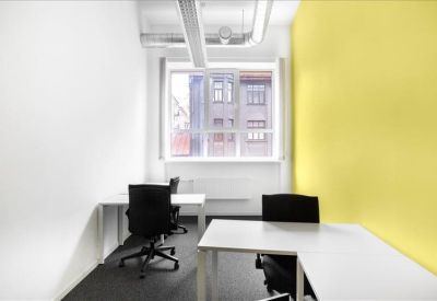 Modern private office suite featuring a bright yellow accent wall and two workstations.
