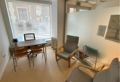Meeting space with large windows and wooden chairs.