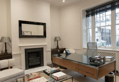 Traditional boardroom with a long polished wooden table and high-backed chairs.