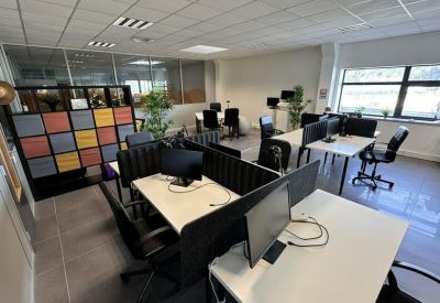 Bright open-plan workspace with several desks and computers.