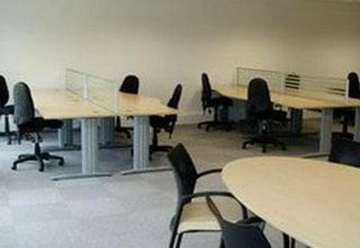 Spacious workspace with multiple workstation clusters and a central oval meeting table.