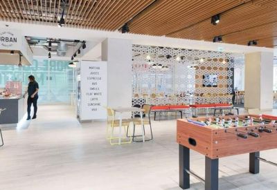 Large breakout area with a foosball table, wooden ceiling slats, and an onsite cafe.