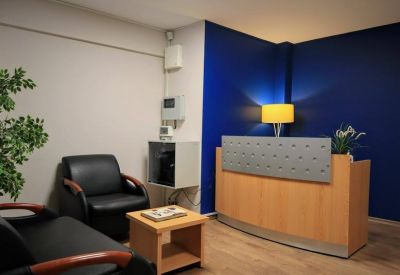 Reception area featuring a wooden front desk and a vibrant blue accent wall.