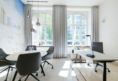 Bright office with two round tables and modern chairs.
