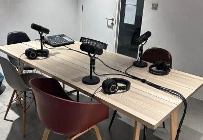 Dedicated podcasting studio equipped with microphones, headphones, and a sound mixer on a wooden table.