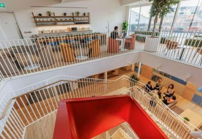 Multi-level atrium view showing a modern staircase and communal lounge areas.