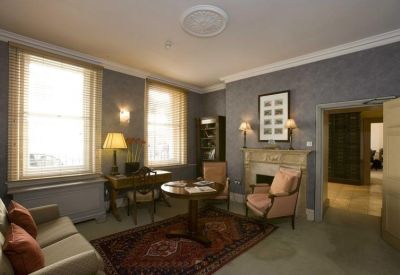Sophisticated lounge area featuring blue textured walls, a fireplace, and classic armchairs.