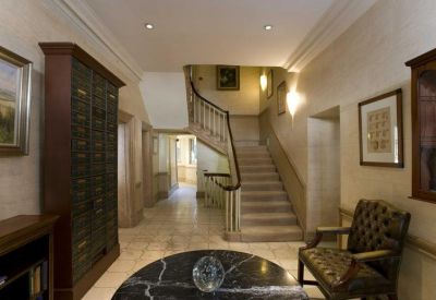 Grand reception hall with a stone staircase and elegant dark wood cabinetry.