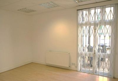 Bright office space with a white radiator and security gate on a large window.