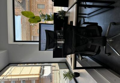 Modern open-plan office with quad desk setup and minimalist design.