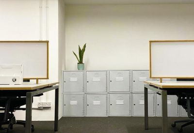 Lockers and workspace with white privacy screens and a snake plant.