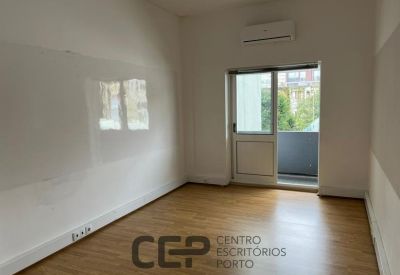 Bright private office featuring a glass door leading to a small balcony.