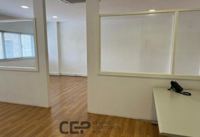 Interior corridor view showing glass-partitioned office spaces and bright lighting.