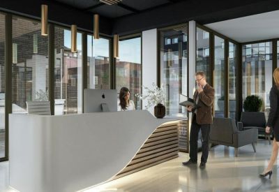 Modern reception area with a curved white desk and wood accents.