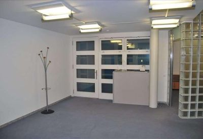 Reception foyer featuring a minimalist grey desk and a unique metal coat rack.