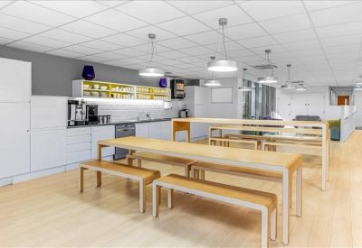 Bright communal kitchen and dining area with wooden benches and modern lighting.