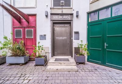 Modern building entrance with a minimalist grey door flanked by red and green doors.