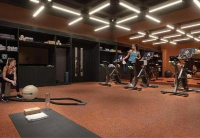 Sleek fitness center with stationary bikes and linear overhead lighting.