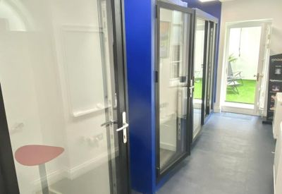 Hallway featuring glass-door phone booths and a bright blue accent wall.