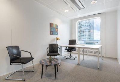 Bright private office featuring a white desk and a large window with city views.