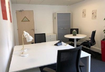 Private office with white desks, black chairs, and a sliding storage cabinet.